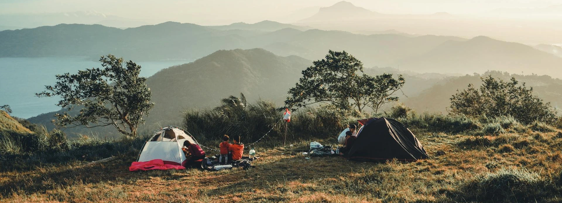 Organized campsite layout with a tent, tarp, cooking area, water station, gear zone, and clear walking paths.
