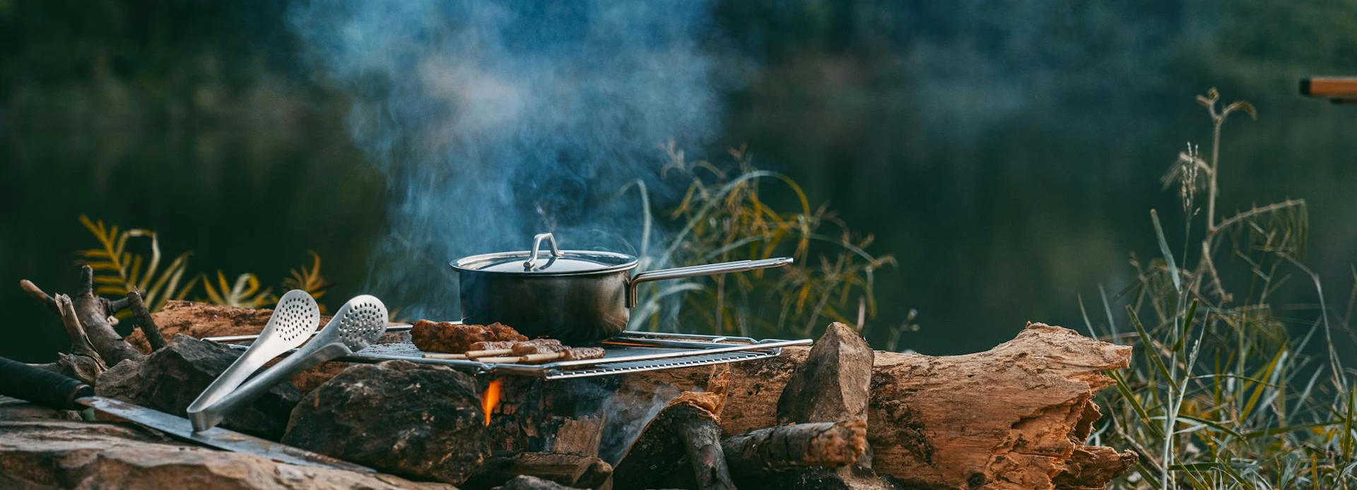 Beginner camp kitchen setup with a camping stove, cookware, cooler, water container, cleanup sink, and food prep area.